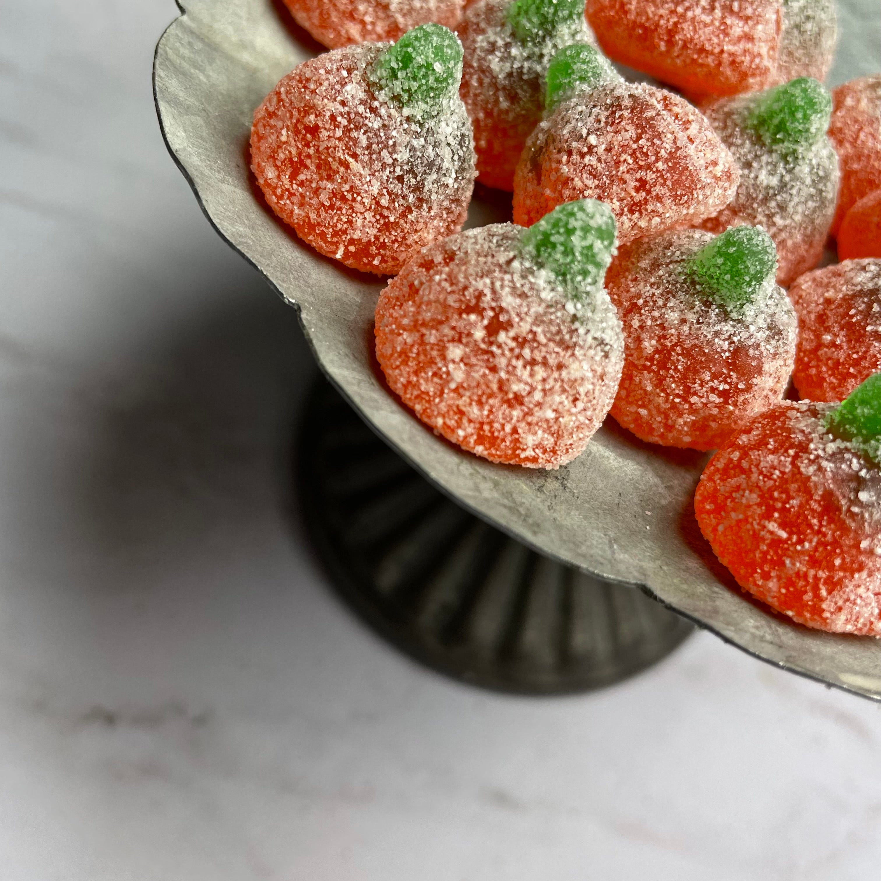 close up of sour gummy pumpkins on a festive tray
