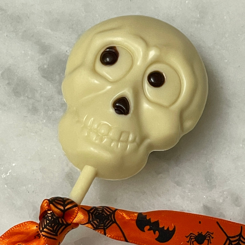 White chocolate skull lollipop with dark chocolate to accent the eyes and nose.